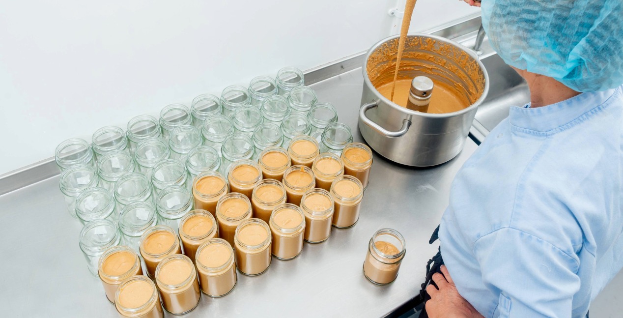 Katie putting fresh Utta Nutta into jars