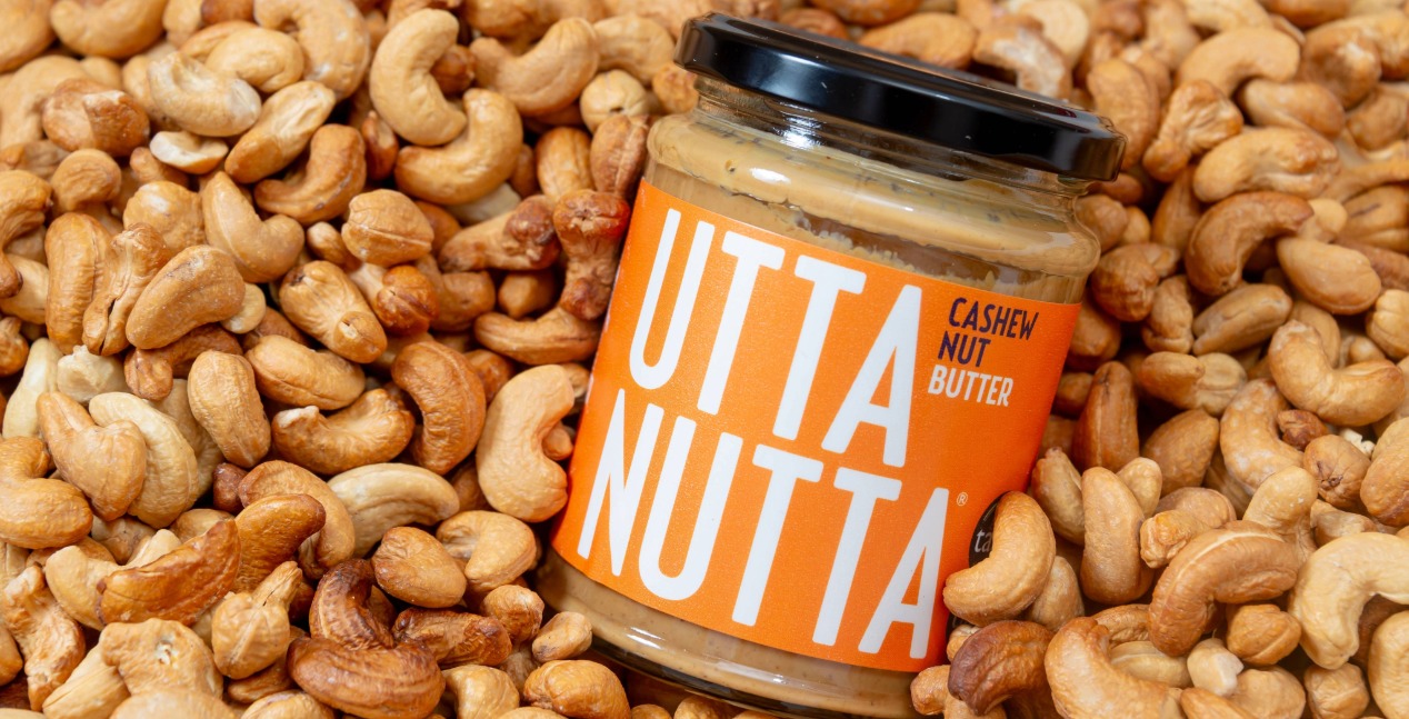 A jar of cashew nut Utta Nutta resting on a pile of cashews